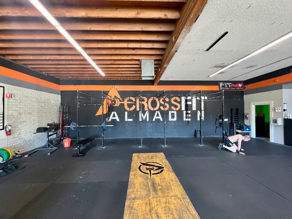 The main training floor at CrossFit Almaden, with the painted CrossFit Almaden wall mural behind the rig