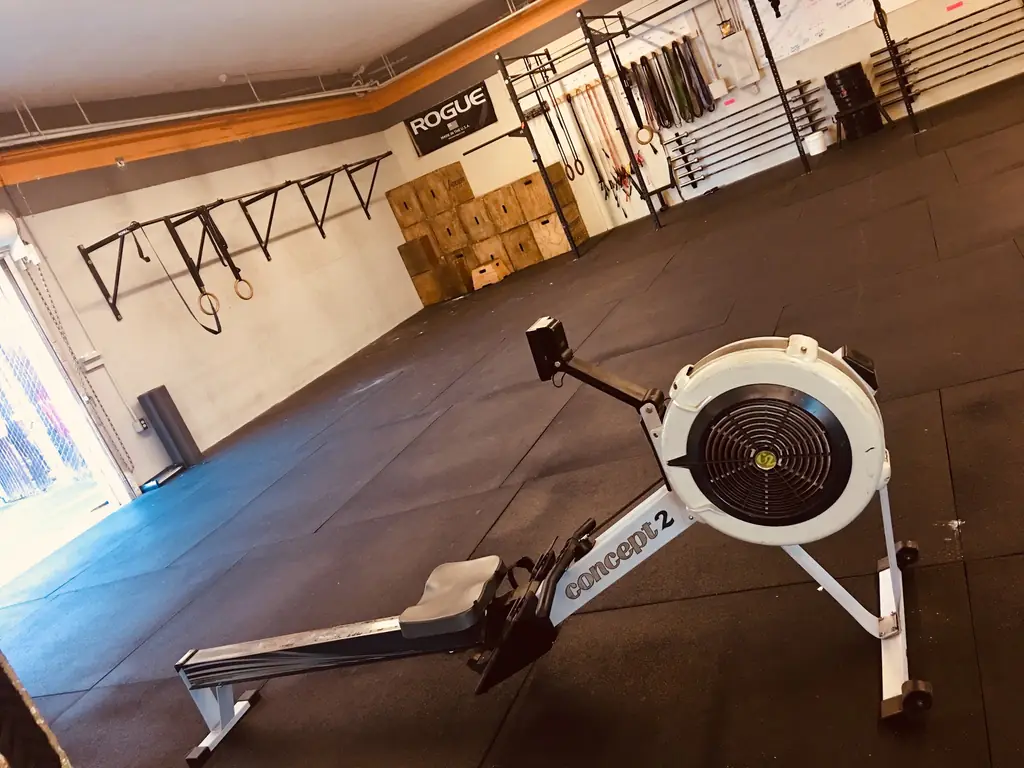 Concept2 rower, plyo boxes and rings on the training floor at CrossFit Almaden